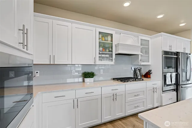 a kitchen with granite countertop white cabinets and stainless steel appliances
