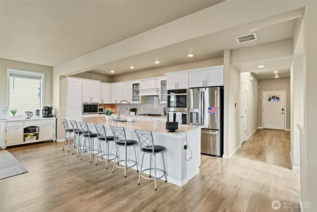 a open kitchen with white cabinets and stainless steel appliances