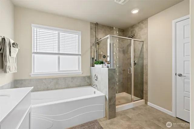 a bathroom with a large tub a shower and view