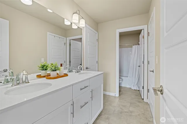a bathroom with a sink double vanity granite and a mirror