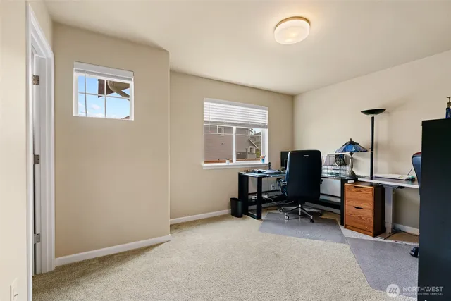 a view of a workspace with furniture and a window