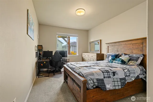 a bedroom with a bed table chair and a window