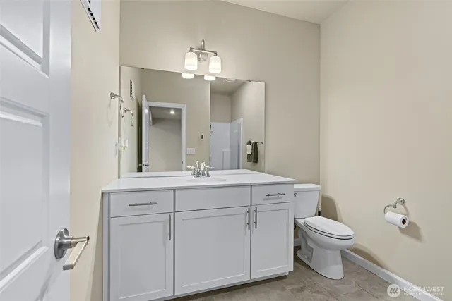 a bathroom with a toilet a sink and mirror