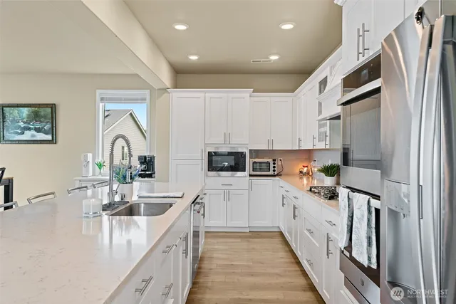 a kitchen with white cabinets and sink