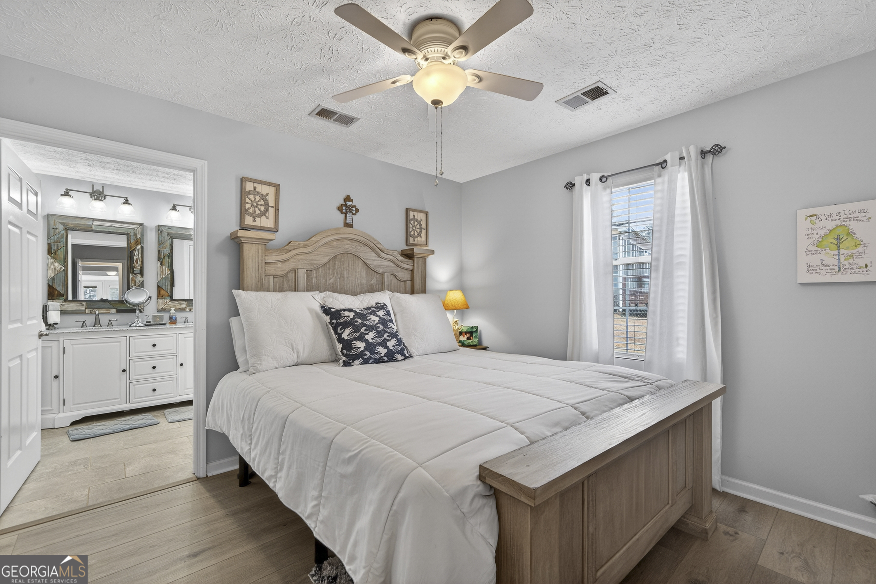 285 Clubhouse Road Eatonton, GA 31024 - Photo 29 of 44 a bedroom with a bed and a chandelier