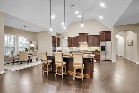 a dining room with furniture a chandelier and wooden floor