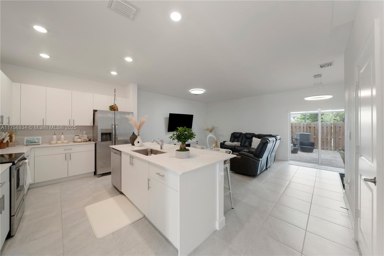 26431 Southwest 148th Avenue Homestead, FL 33032 - Photo 2 of 29 a kitchen that has a lot of white cabinets and couches