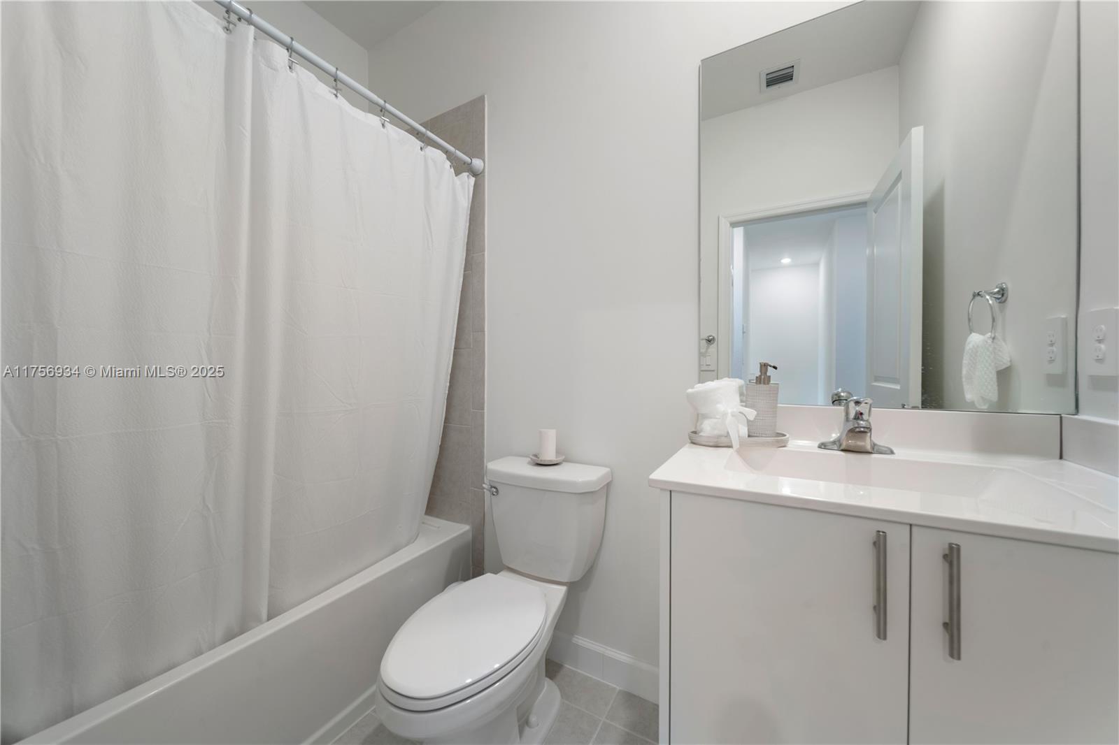 26431 Southwest 148th Avenue Homestead, FL 33032 - Photo 21 of 29 a bathroom with a toilet a sink and a mirror