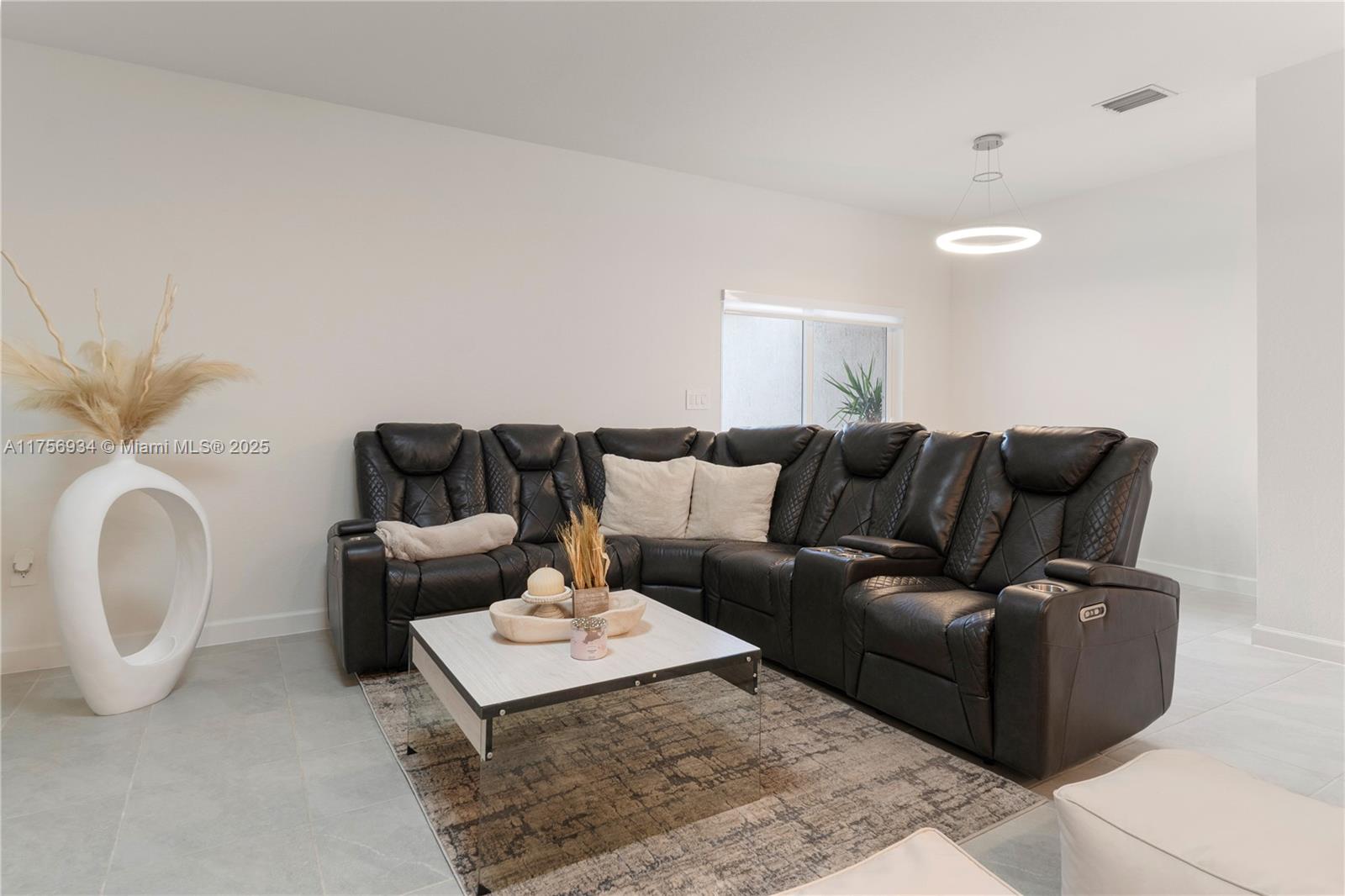 26431 Southwest 148th Avenue Homestead, FL 33032 - Photo 27 of 29 a living room with furniture a rug and white walls