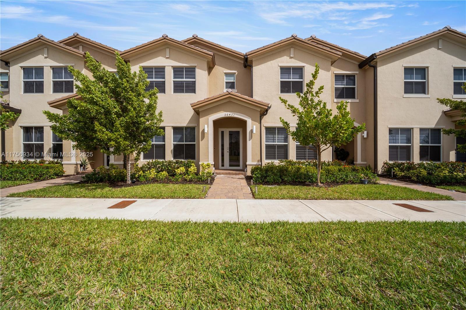 26431 Southwest 148th Avenue Homestead, FL 33032 - Photo 6 of 29 a front view of a house with a yard and garage