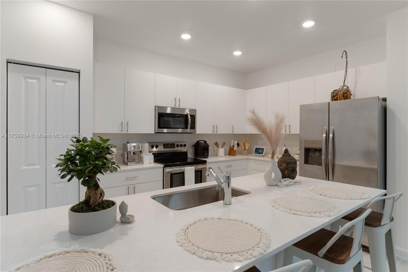 26431 Southwest 148th Avenue Homestead, FL 33032 - Photo 8 of 29 a kitchen with stainless steel appliances kitchen island granite countertop a stove a refrigerator a sink a dining table and chairs with wooden floor