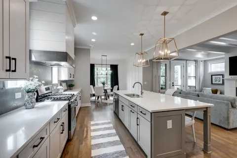 a kitchen with stainless steel appliances a sink stove and cabinets
