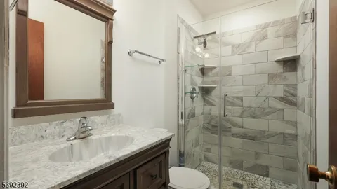 a bathroom with a granite countertop sink toilet and shower