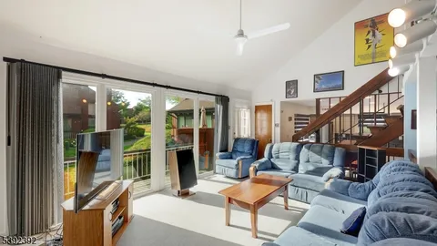 a living room with furniture and a floor to ceiling window