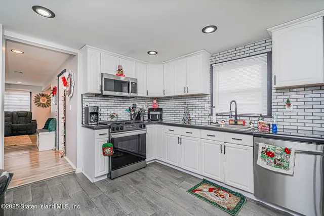 a kitchen with kitchen island granite countertop a sink cabinets and stainless steel appliances