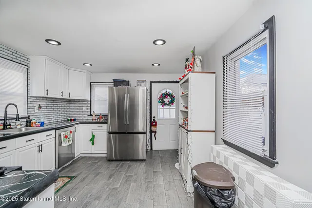 a kitchen with a refrigerator a stove top oven a sink and cabinets