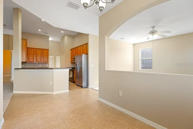 a view of a kitchen with refrigerator and wooden cabinets