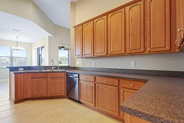a kitchen with granite countertop cabinets stainless steel appliances and a window