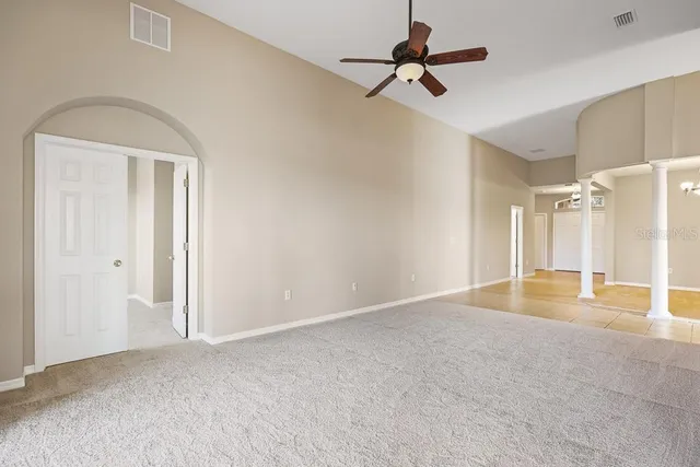 an empty room with a window and a ceiling fan