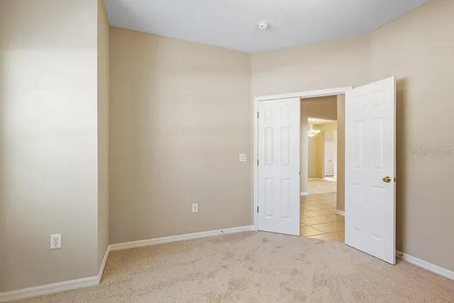 a view of an empty room with a chandelier fan