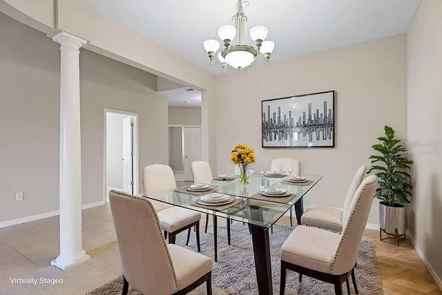 a view of an empty room with chandelier fan