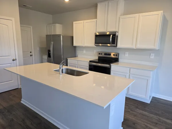 a kitchen with stainless steel appliances a stove refrigerator sink and microwave