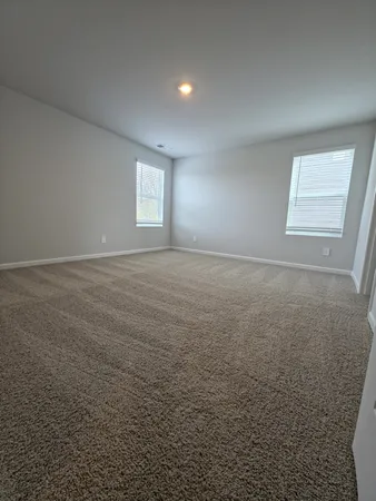 an empty room with windows and closet