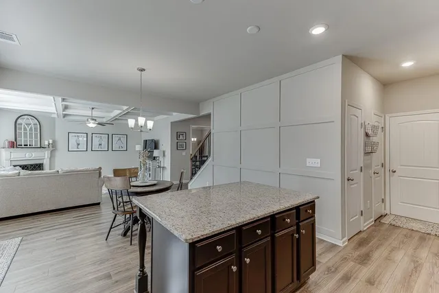 a kitchen with a stove a sink dishwasher a kitchen island with wooden cabinets and floor