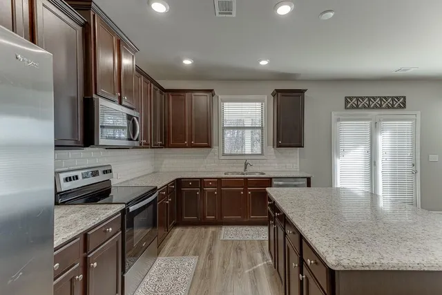 a view of a hallway with workspace and livingroom with furniture