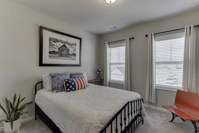 a bed room with a bed and a painting on the wall