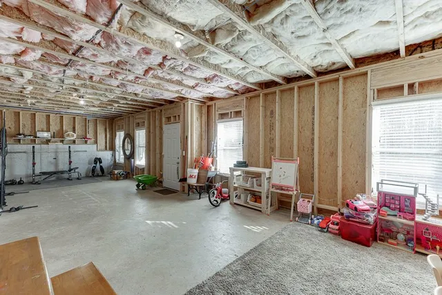 a backyard of a house with large trees and wooden fence