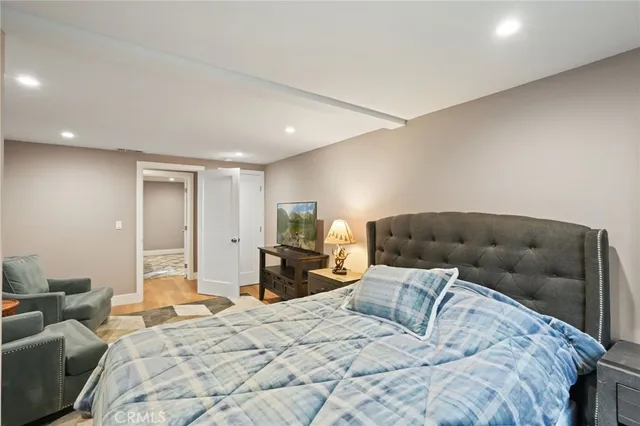 a bedroom with a bed and wooden floor