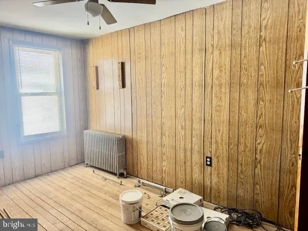 a view of a hallway with furniture and wooden floor