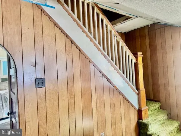 a view of staircase with railing and white walls