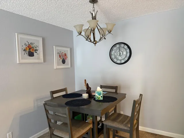 a view of a dining room with a table and a clock