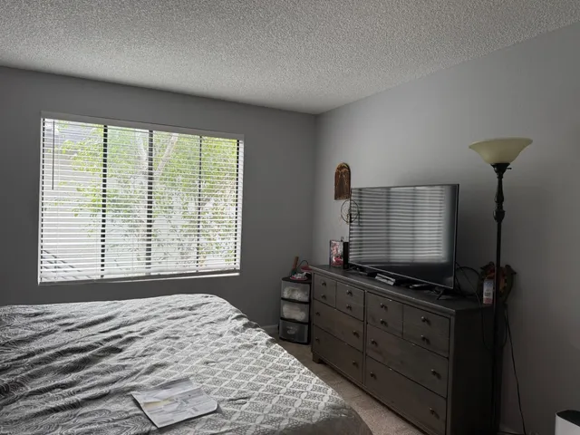 a bedroom with a bed and a flat tv screen on a dresser
