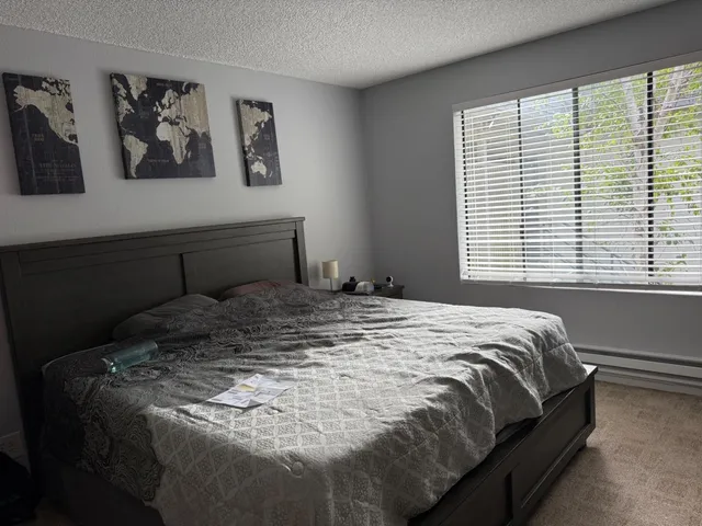 a bed sitting in a bedroom next to a window
