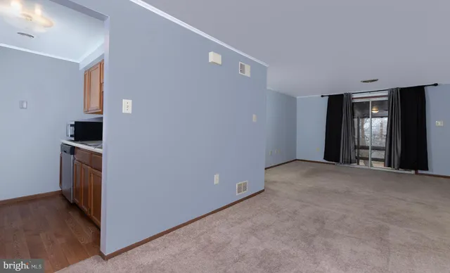 a view of empty room with wooden floor