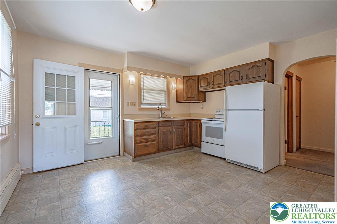 1115 Chestnut Street Coplay, PA 18037 - Photo 6 of 32 a kitchen with a refrigerator a sink and cabinets