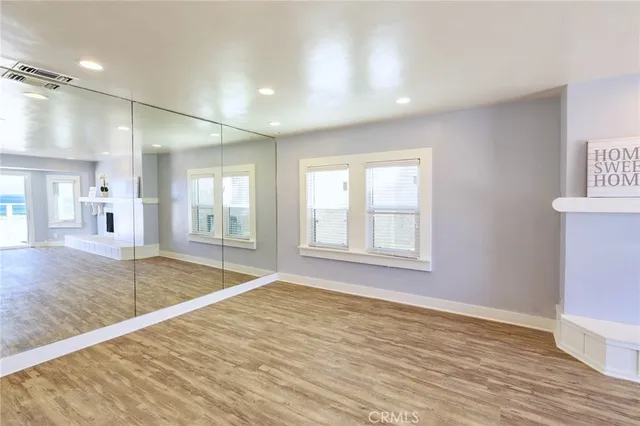 a kitchen with a sink dishwasher a stove and white cabinets with wooden floor