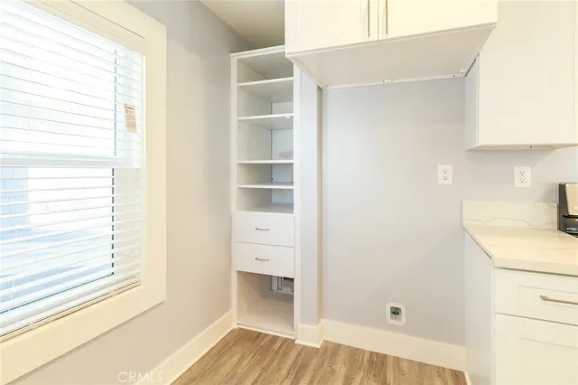 an empty room with wooden floor and ceiling fan