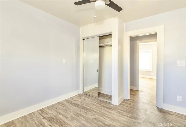 a view of a big room with wooden floor and a kitchen