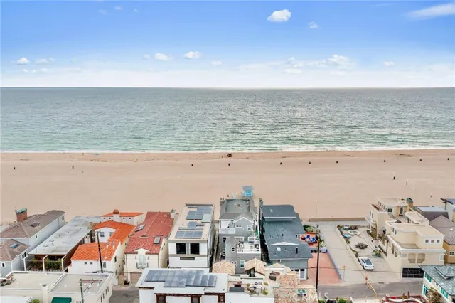 a view of an empty room with wooden floor fireplace and a window
