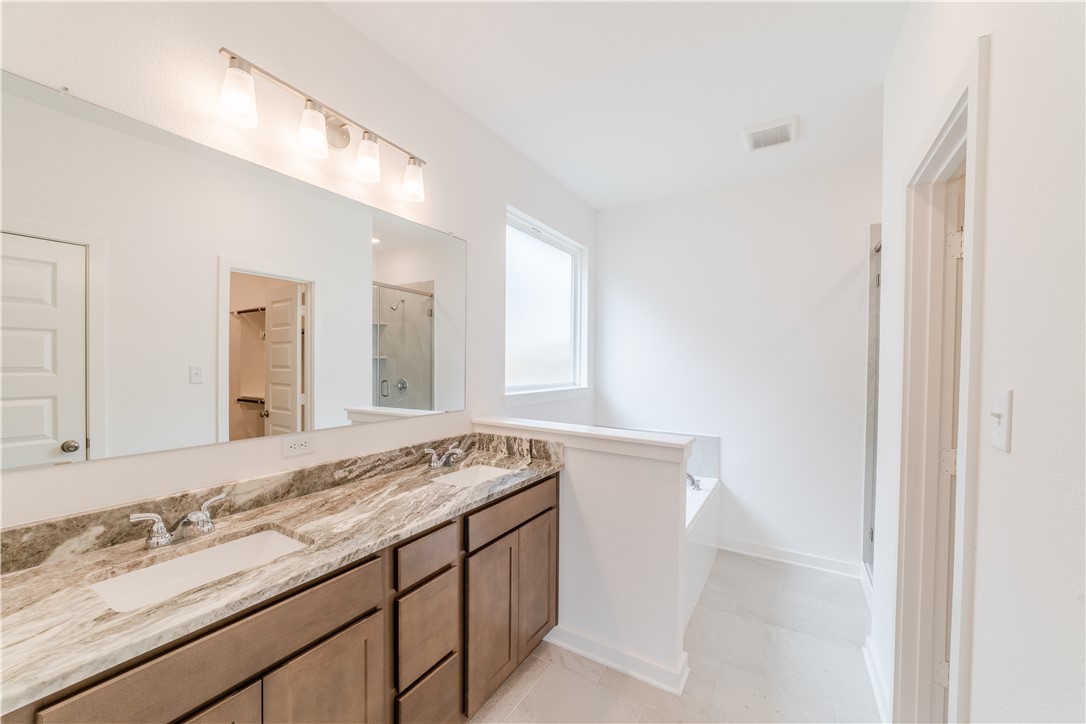 1901 Sebright Drive Bryan, TX 77807 - Photo 10 of 13 a bathroom with a granite countertop sink and a mirror