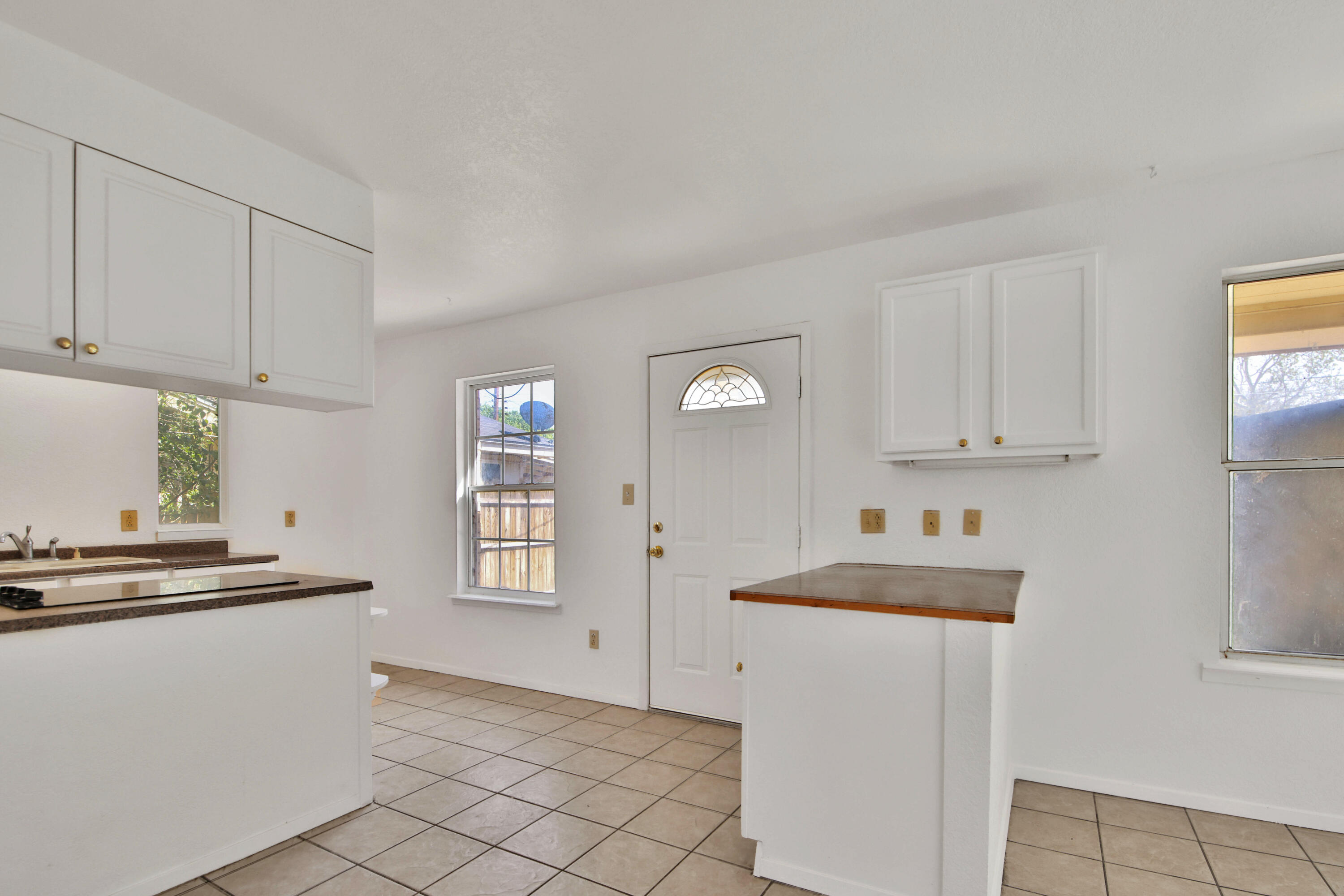 4913 56th Street Lubbock, TX 79414 - Photo 12 of 32 a kitchen with cabinets and window