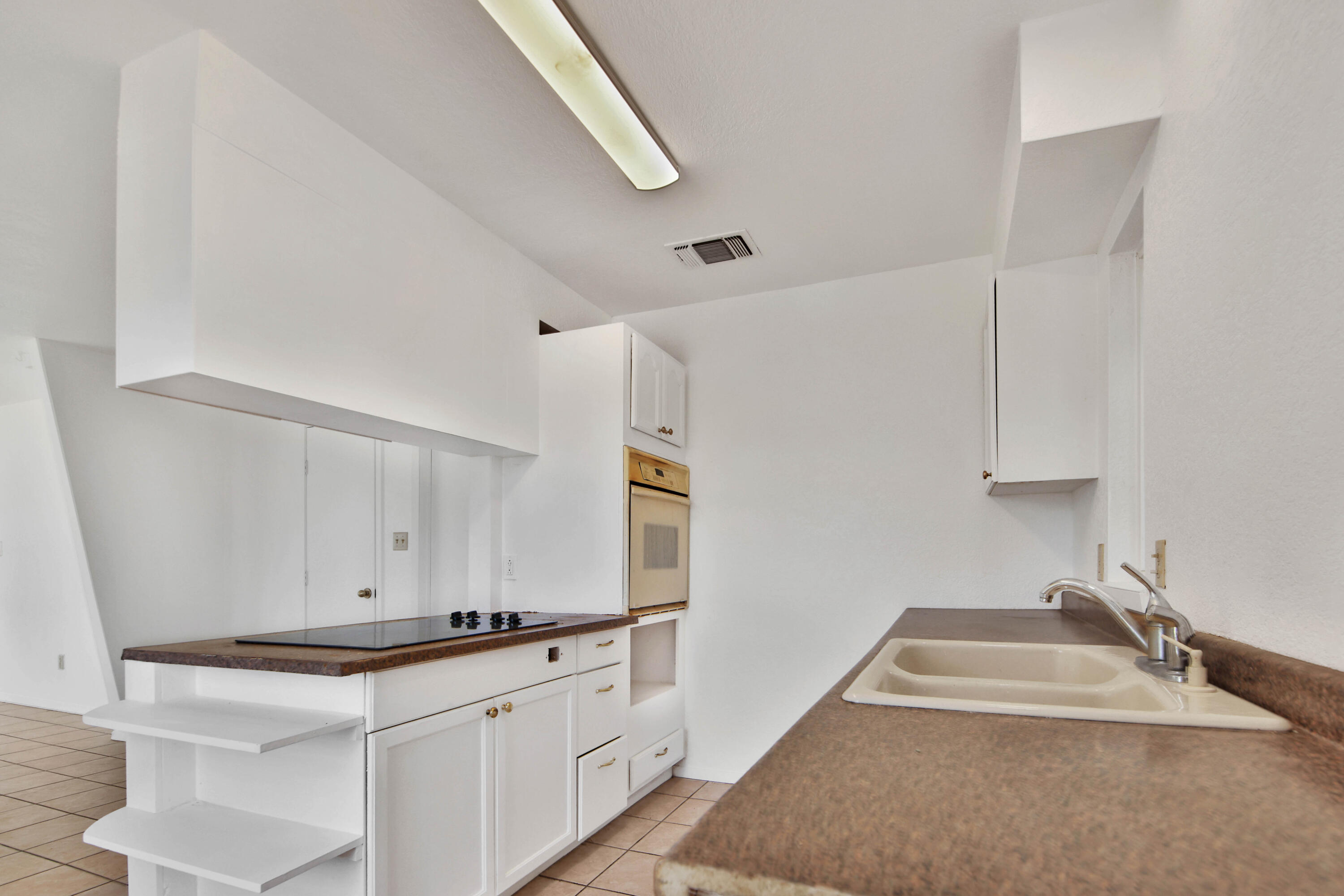 4913 56th Street Lubbock, TX 79414 - Photo 13 of 32 a kitchen with granite countertop a sink and a stove top oven