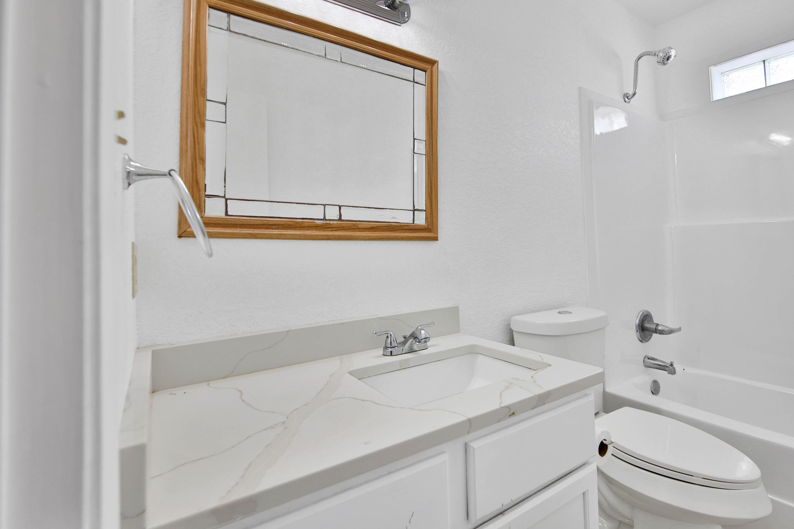 4913 56th Street Lubbock, TX 79414 - Photo 28 of 32 a bathroom with a granite countertop sink vanity mirror and toilet