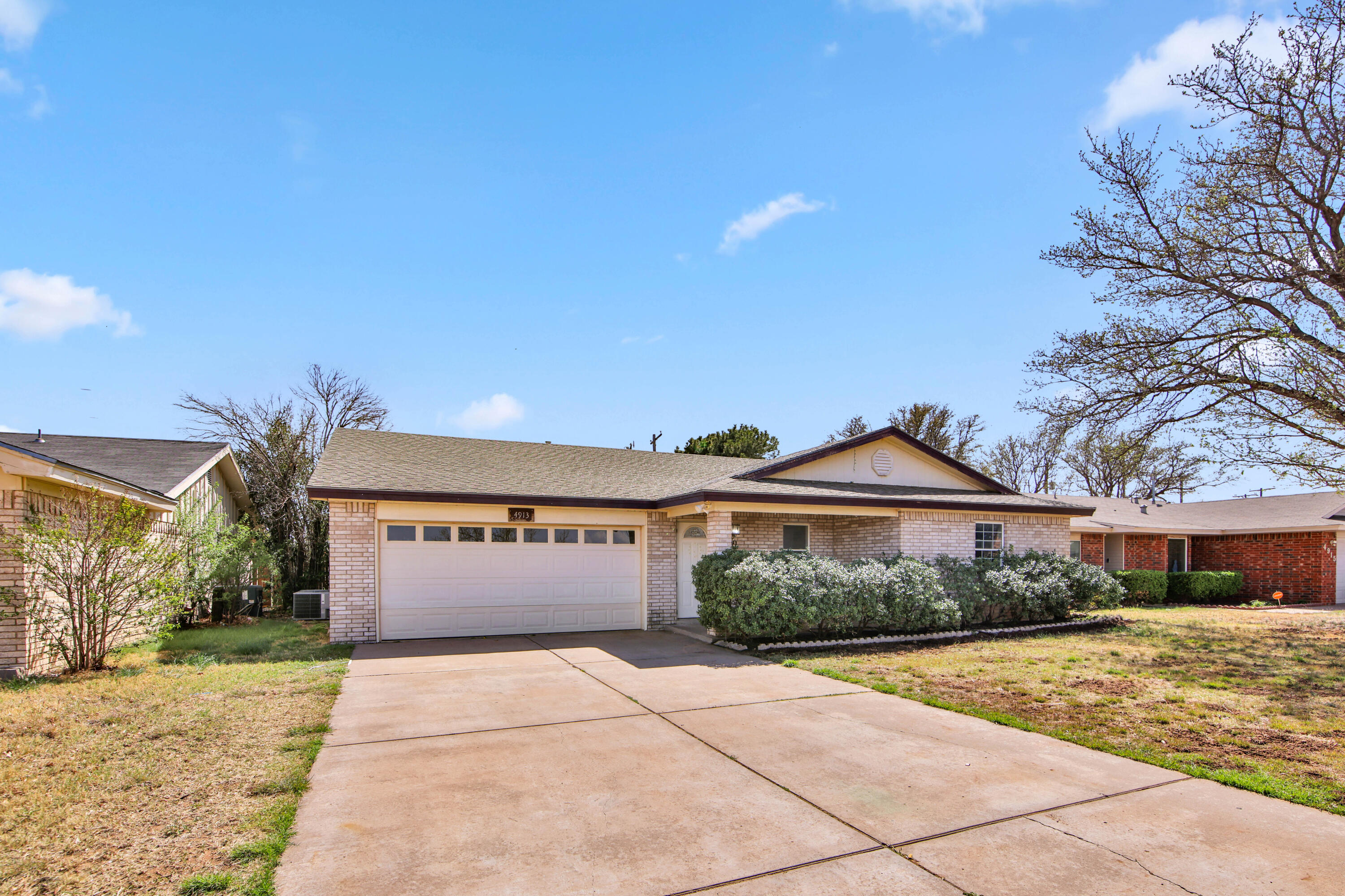 4913 56th Street Lubbock, TX 79414 - Photo 3 of 32 a front view of a building with a garden and a pathway