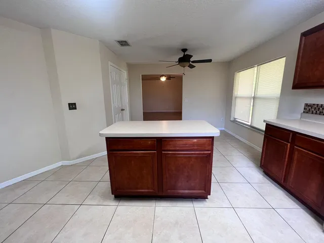 a room with a granite countertop sink and a stove top oven