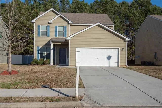 a view of a house with a yard and garage